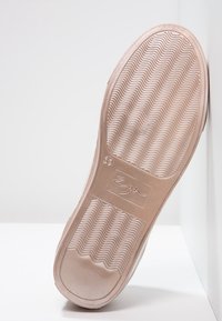 Semelle d'une chaussure beige avec un motif de semelle en vagues, taille 39, et un logo rectangulaire au centre de la semelle.