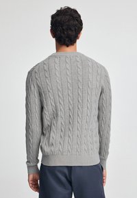 Grau gestrickter Pullover mit Kabelmustern, gerippten Bündchen und Saum sowie einem Rundhalsausschnitt. Weiche Textur und lockere Passform, von hinten gezeigt.