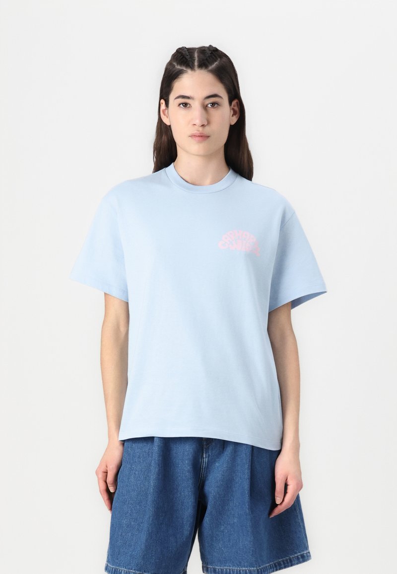 Ljusblå bomulls t-shirt med korta ärmar, rund hals, med en rosa grafik på vänster bröstaområde. Mjuk textur, avslappnad passform.