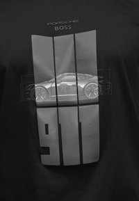 Μαύρο πουκάμισο με γκρι γραφικό Porsche 911, πλαϊνή όψη του σπορ αυτοκινήτου και μεγάλες κάθετες ρίγες με τον αριθμό "911".