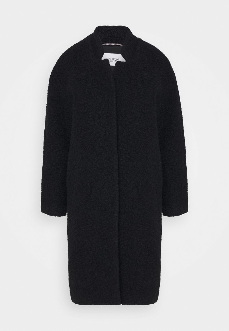 Cappotto nero in tessuto testurizzato, con una silhouette dritta, maniche lunghe e colletto alla cinese. Apertura frontale senza chiusure visibili.