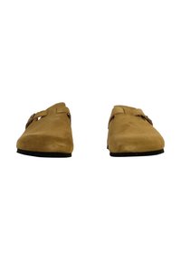 Chaussures en daim marron à enfiler avec deux sangles réglables et un bout arrondi. Semelles noires plates, texture lisse et design minimaliste.