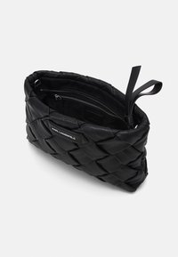 Svart läderkuvertväska med en strukturerad vävd design, en zippered innerficka och en avtagbar handledsrem.