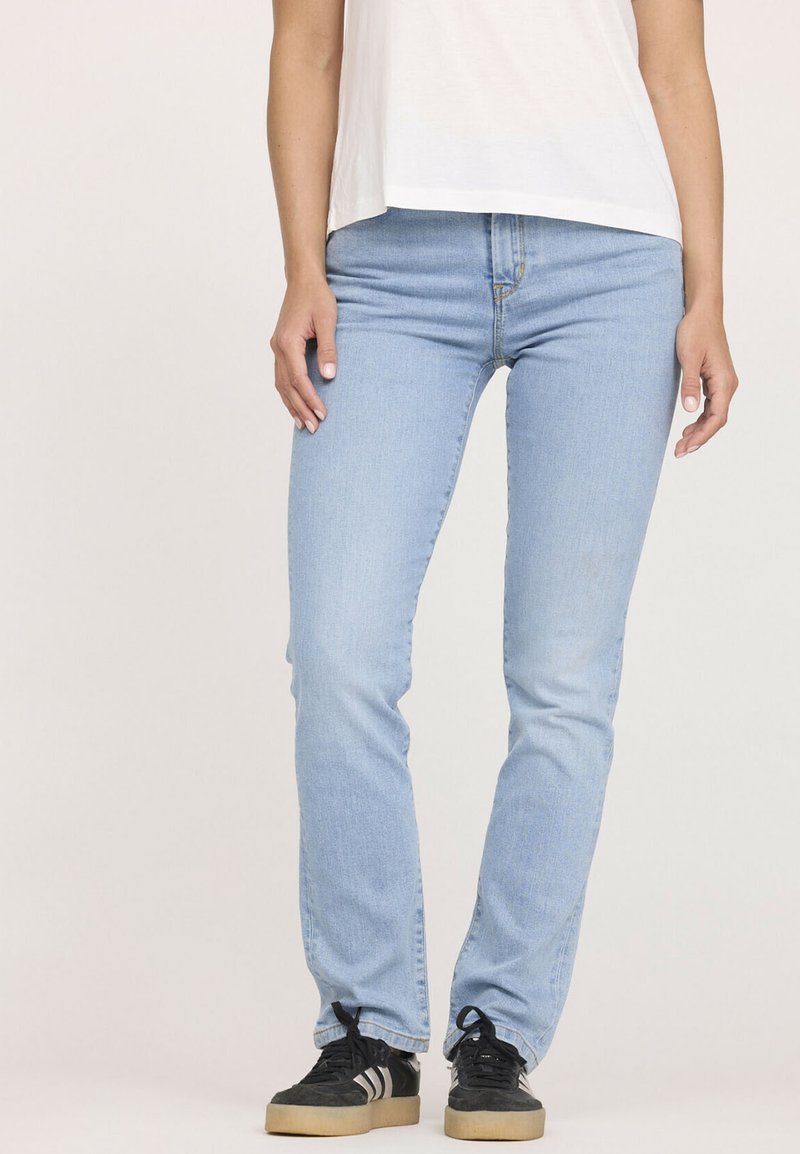 Jean en denim bleu clair avec une coupe droite, doté d'une fermeture éclair, d'un design à cinq poches et de détails de couture subtils.