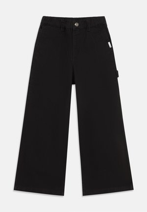 Sorte bukser med vide ben med knap og elastisk talje, bæltestropper, sidelommer og et lille hvidt mærke på højre side.