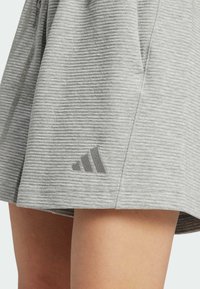 Grå kjol i ribbstickat tyg med avslappnad passform, med en subtil Adidas-logotyp i matchande grått nära fållen.