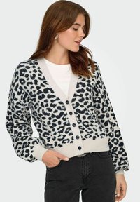 Leopardmönstrad cardigan i mjukt, texturerat tyg med marinblå fläckar på en ljusgrå bakgrund, V-hals och knäppning fram.