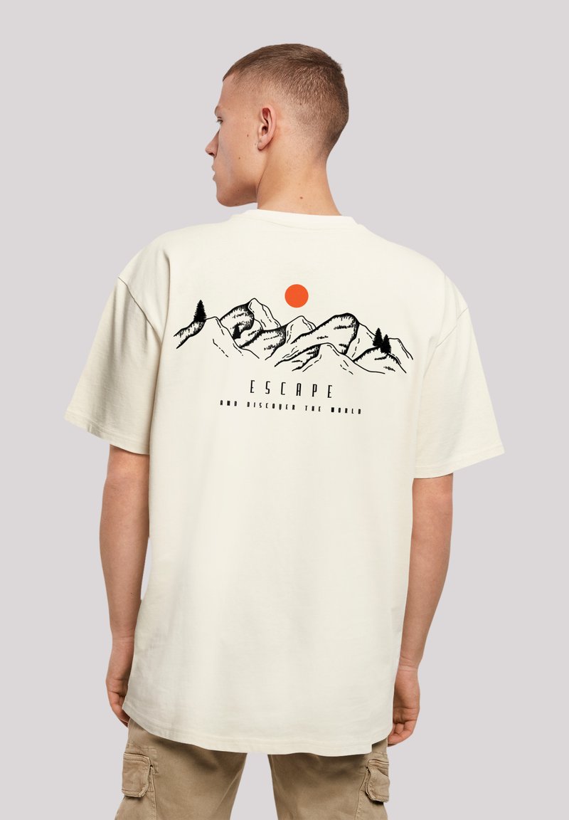 Cotton t-shirt in off-white, featuring a graphic of mountains, an orange sun, and the text "ESCAPE AND DISCOVER THE WORLD" on the back.