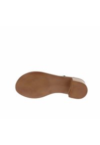 Suola di scarpa in gomma marrone con una superficie testurizzata, dotata di un leggero tacco e di una forma arrotondata. Il materiale sembra durevole e flessibile.