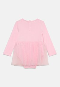 Body a maniche lunghe in cotone rosa chiaro con un sovrapposto in tulle trasparente in vita. Presenta una chiusura con bottone sul retro e una texture morbida.