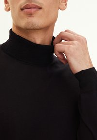 Schwarzer hochgeschlossen pullover aus feinem Strickstoff, mit geripptem Kragen und Bündchen, glatter Textur und enganliegender Passform.