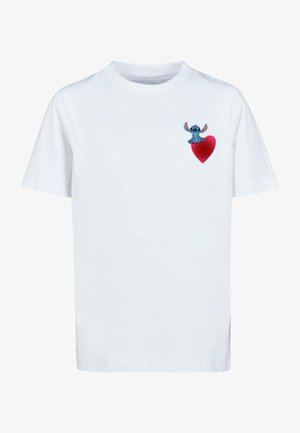 Tricou alb din bumbac, cu un grafic colorat al unui personaj care stă pe o inimă roșie, situată în zona stângă a pieptului.