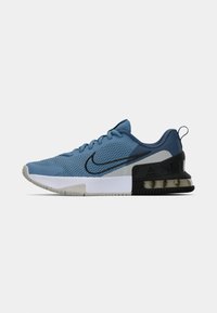 Nike sneakers featuring a light blue mesh upper, black accents, a cushioned midsole, and a textured rubber outsole.
