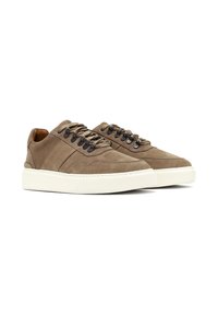 Zapatillas de ante marrón con punteras redondas, cordones a tono y suela de goma blanca, que presentan sutiles detalles de costura y un tobillo acolchado.