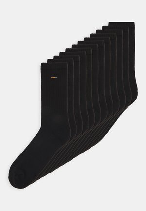 Mustad mustriga mustad sokid, mis on korralikult virnastatud, tugevdatud varbaosaga ja väikese oranži logoga. Segakanga materjal.