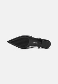 Shoe de salto alto preto com bico fino, material superior liso e sola de borracha texturizada com ranhuras horizontais.