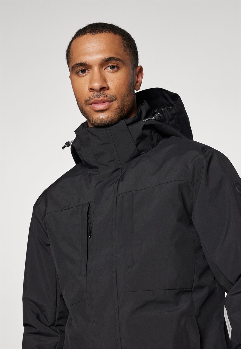 Schwarze wasserdichte Jacke mit hohem Kragen, verstellbare Kapuze, Fronttaschen und glatter Textur; verfügt über einen Reißverschluss und Kordelzug-Details.