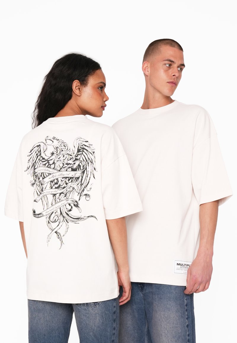 Hvid oversized t-shirt med et detaljeret sort grafisk motiv af enørn og bånd på ryggen. Har korte ærmer og en rund hals.