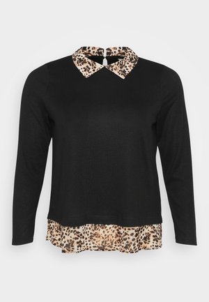 Svart topp med lange ermer som har en leopardmønstret krage og en rynket leopardmønstret hem for ekstra detaljer og tekstur.