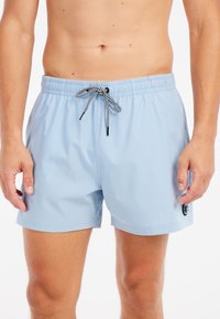 Svetlomodré plavky vyrobené z ľahkého materiálu, s elastickým pásom a čierno-bielym sťahovacím šnúrkou a detailom loga.