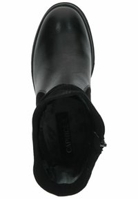 Botín negro de cuero hasta el tobillo con textura suave, puntera redondeada, lateral elástico y tacón bajo. Interior forrado con tejido suave.