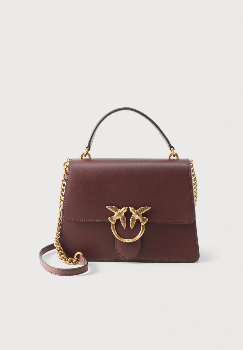 Καφέ δερμάτινη τσάντα χειρός με κορυφαία λαβή και χρυσή αλυσίδα, με χρυσό κούμπωμα σε σχήμα δαχτυλιδιού διακοσμημένο με δύο διακοσμητικά πουλιά.