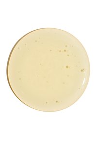 Runde, blassgelbe Flüssigkeit mit kleinen Blasen, auf einem weißen Hintergrund präsentiert, glatte Textur mit glänzender Oberfläche.