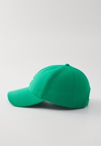 Boné de basebol verde com aba curva, feito de tecido sólido, apresentando um emblema bordado na frente e um botão no topo.