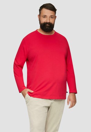 Rode lange mouwen T-shirt van katoen, met een ronde hals en een ontspannen pasvorm. Gecombineerd met lichtgekleurde corduroy broek.