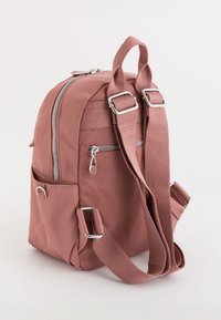 Mochila de tela rosa con herrajes plateados, correas ajustables y bolsillo frontal con cremallera. Cuenta con un bolsillo lateral y un asa en la parte superior.