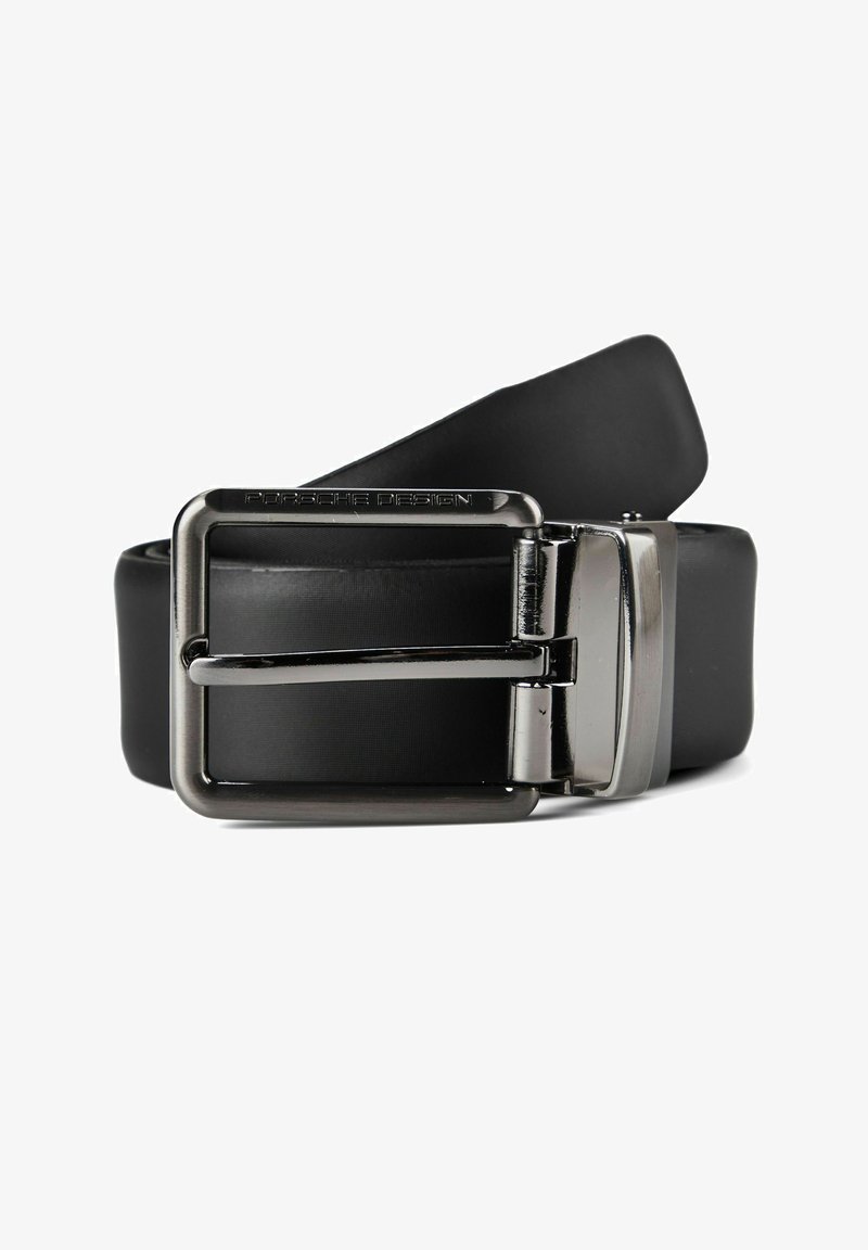 Ceinture en cuir noir avec une boucle rectangulaire argentée polie gravée "Porsche Design", enroulée sur un fond blanc.