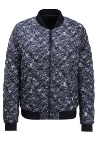 Steppjacke aus schwarzem Stoff mit einem weißen geometrischen Muster, ausgestattet mit einem gerippten Kragen, Bündchen und Saum. Mittlerer Reißverschluss.