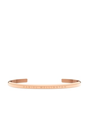Bracelet jonc ouvert en or rose avec "DANIEL WELLINGTON" gravé sur la surface extérieure, design minimaliste.