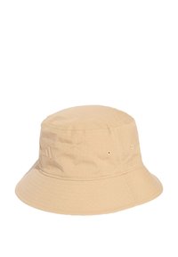 Beige bucket hat made of textured fabric, featuring a flat top, wide brim, and subtle logo detailing on the side.