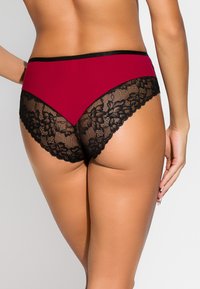 Majtki z wysokim stanem w kolorze burgundowym z czarną koronką. Posiadają gładki materiał z przodu oraz skomplikowany, kwiatowy wzór koronki z tyłu.