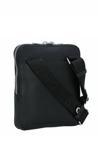 Bolso cruzado de cuero negro con superficie texturizada, cremallera plateada y correa ajustable con marca en relieve. Forma rectangular compacta.