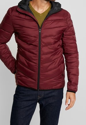 Bordeaux pufferjack met een strakke pasvorm en een zwarte capuchon. Geverfde, gewatteerde oppervlakte met een ritssluiting aan de voorkant en zijzakken.