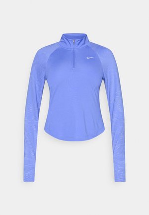 Długi rękaw sportowej bluzki w jasnofioletowym kolorze z półzamkowym kołnierzem. Ozdobiona teksturowanymi detalami na rękawach oraz logo Nike na piersi.