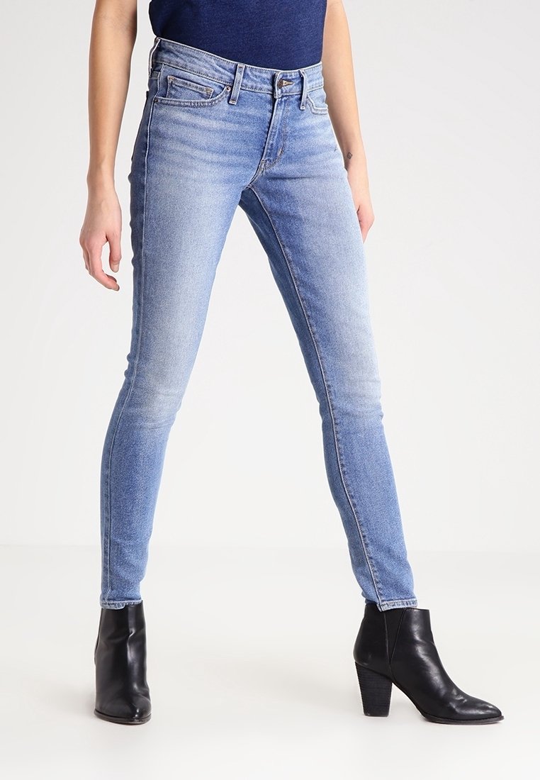 Jeans skinny azul claro con cintura alta, que cuentan con una textura suave y un leve desgastado. Combinados con botas negras hasta el tobillo.