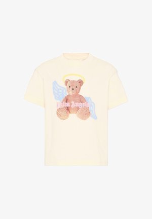 T-shirt couleur crème avec un graphisme d'un ours en peluche arborant une auréole jaune et des ailes d'ange bleues, accompagné du texte « Palm Angels ».