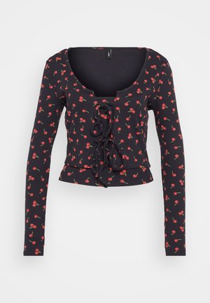 Zwarte lange mouwen crop top met een ronde hals, voorzien van een rood kersenbloempatroon en een geplooid middenstuk met een strikdetail.