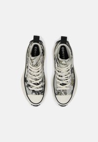 Sneakers typu high-top w szarym i czarnym wzorze z żółtymi akcentami. Posiadają białą podeszwę, czarne akcenty i kremowe sznurowadła.
