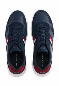 Sneakers atletici navy realizzati in pelle e camoscio, con strisce rosse e bianche, punta rotonda, suola piatta bianca e design con lacci.