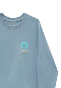 Světle modrá dlouhá halenka s kulatým výstřihem. Vybavena barevným květinovým designem a potiskem loga "VANS" na přední straně. Hladká textura.