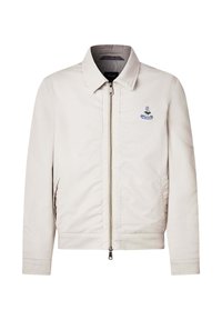 Chaqueta beige con cremallera y cuello, dos bolsillos laterales y un pequeño logotipo bordado en azul en el lado izquierdo del pecho.
