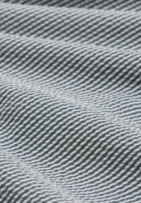 Stripet stof med et mønster af bølgende blå og hvide linjer, med en glat tekstur og blød fald.