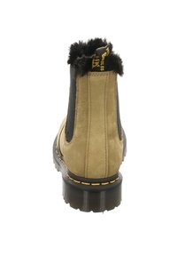 Beige Wildleder-Ankle-Boot mit schwarzen elastischen Seiteneinsätzen und einem flauschigen schwarzen Kragen. Mit einem gelben Nähdetail und einer strukturierten schwarzen Sohle.