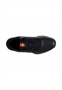 Zapato deportivo negro con parte superior de malla, diseño texturizado, acentuado con detalles en rojo, cordones planos y puntera reforzada.