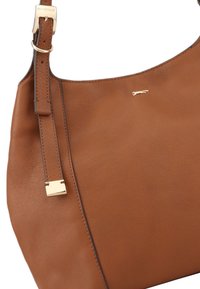 Sac à épaule en cuir marron avec une texture lisse, une fine bandoulière, des accessoires en or et un logo discret. Silhouette incurvée et lignes épurées.
