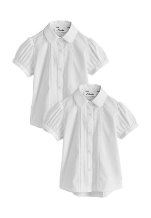 Deux blouses blanches pour enfants à manches courtes avec manches bouffantes, boutonnage devant, cols arrondis et plis décoratifs verticaux.